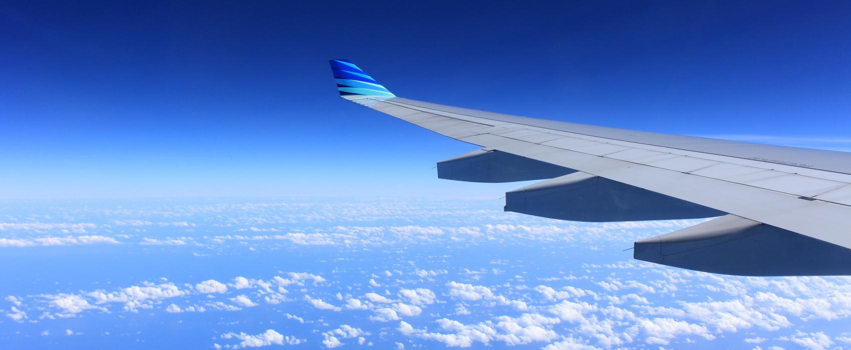 airplane wing in front of a blue sky